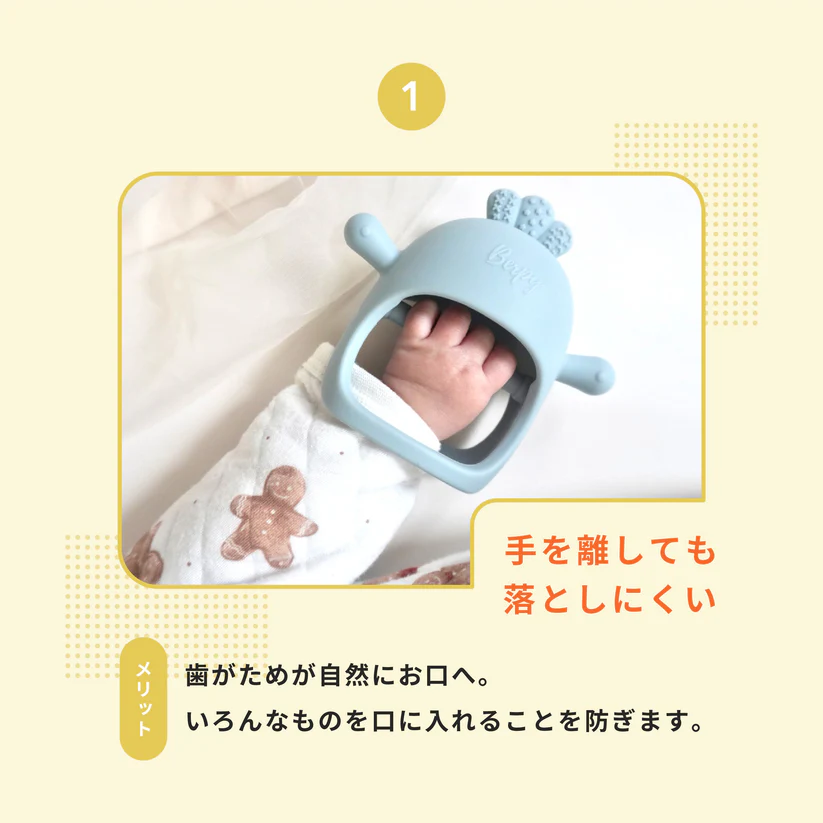 赤ちゃんの手に装着したかみかみチキンが、手を離しても落ちにくいことを紹介する画像。