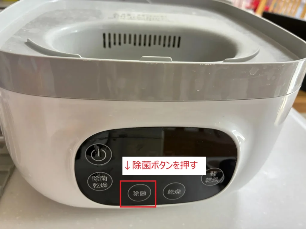 ピジョン ポチっとのお手入れで除菌ボタンを押す様子